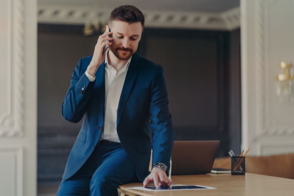 serious-businessman-talking-on-phone-while-sitting